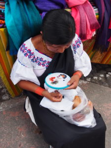 Indigenous Otavaleña sewing in the market