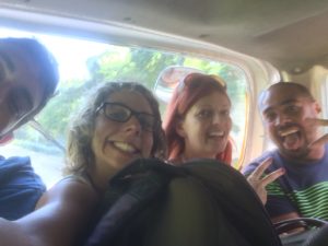 Four people crammed into the backseat of a minivan